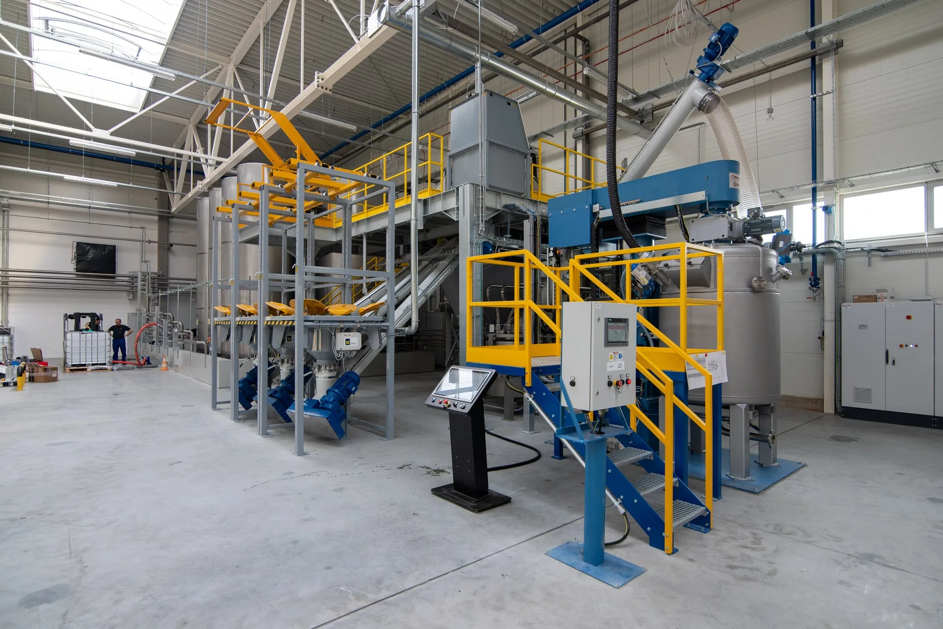 Impianto di produzione compound Wolmec con stazioni big bag, attrezzature per il trasferimento delle polveri, recipiente di miscelazione e pannelli operatore
